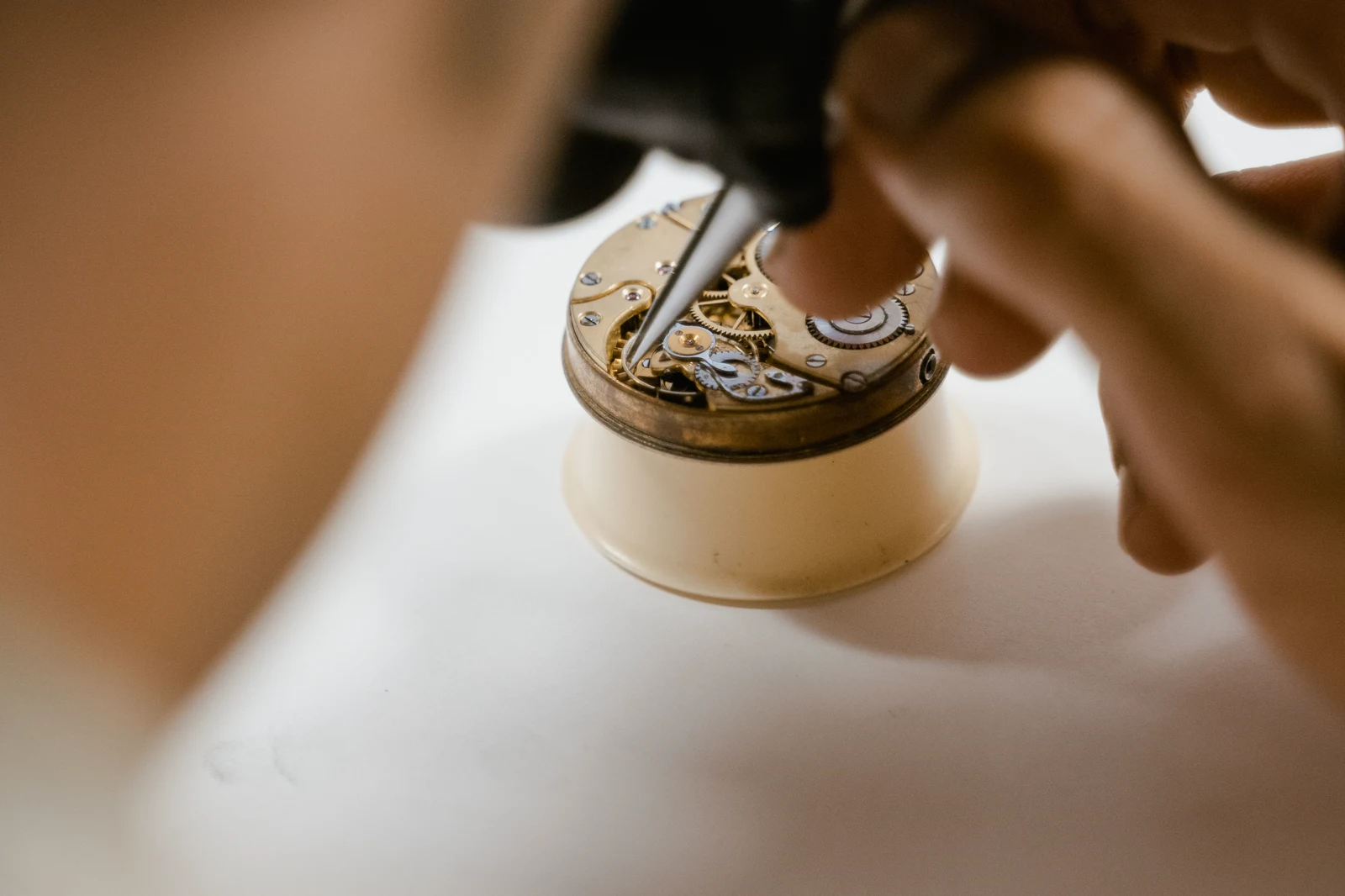 Macro view of a watch movement under precision tweezers