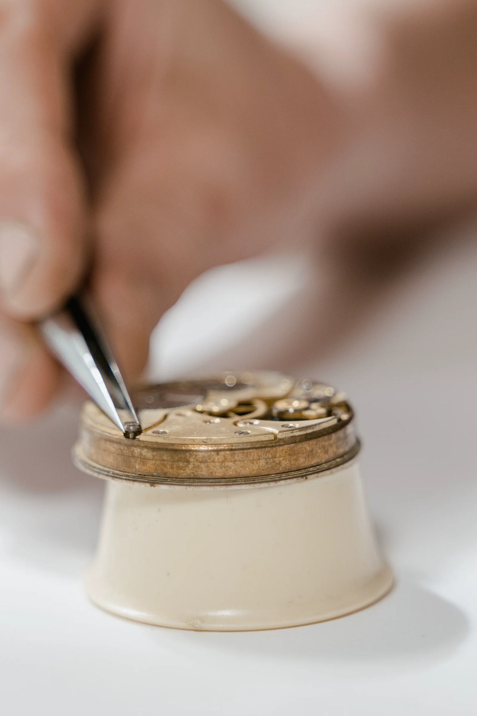 Watchmaker placing a screw into a mechanical movement