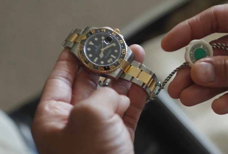 Hands inspecting a timepiece before acquisition